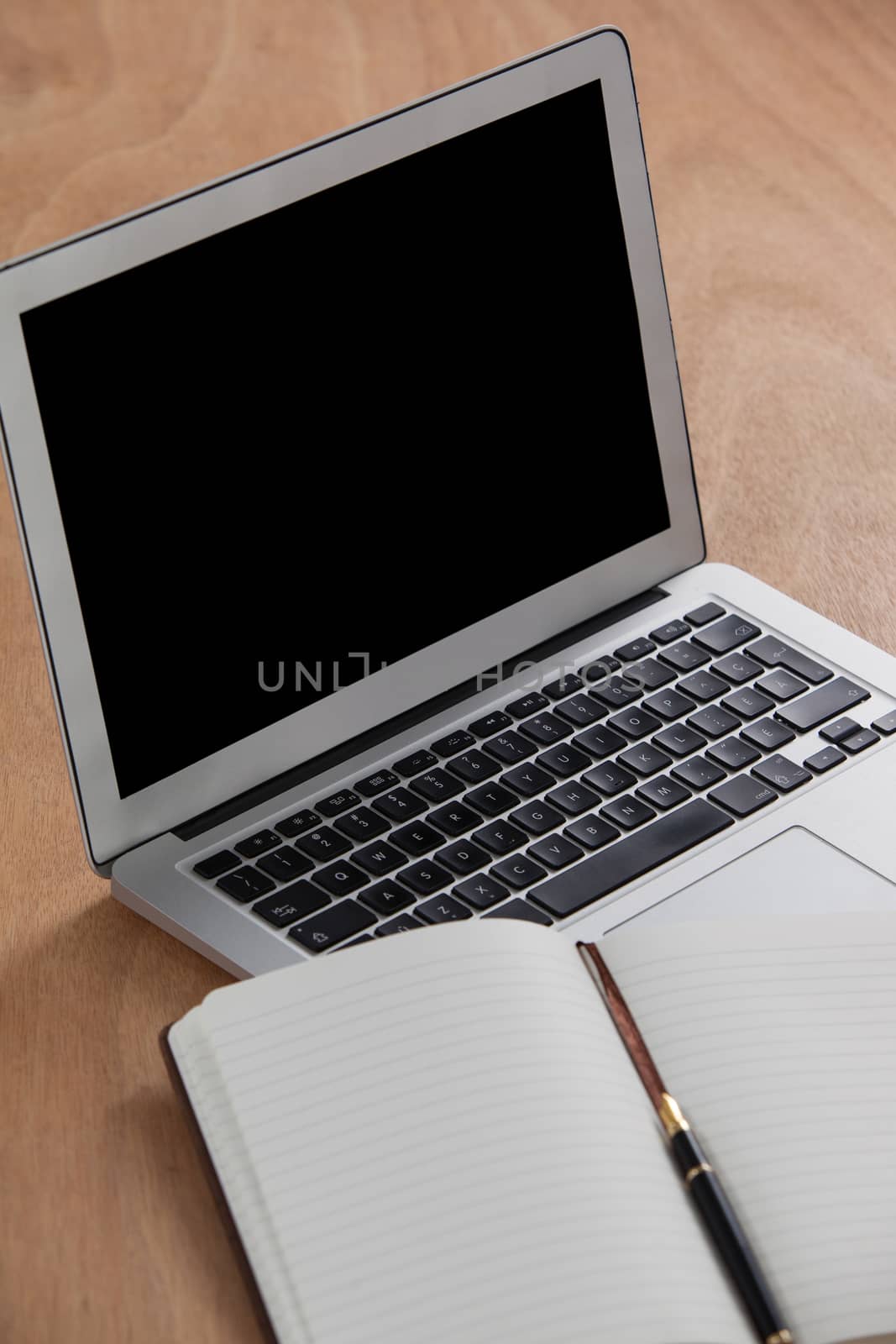 Close-up of laptop and organizer on wooden background