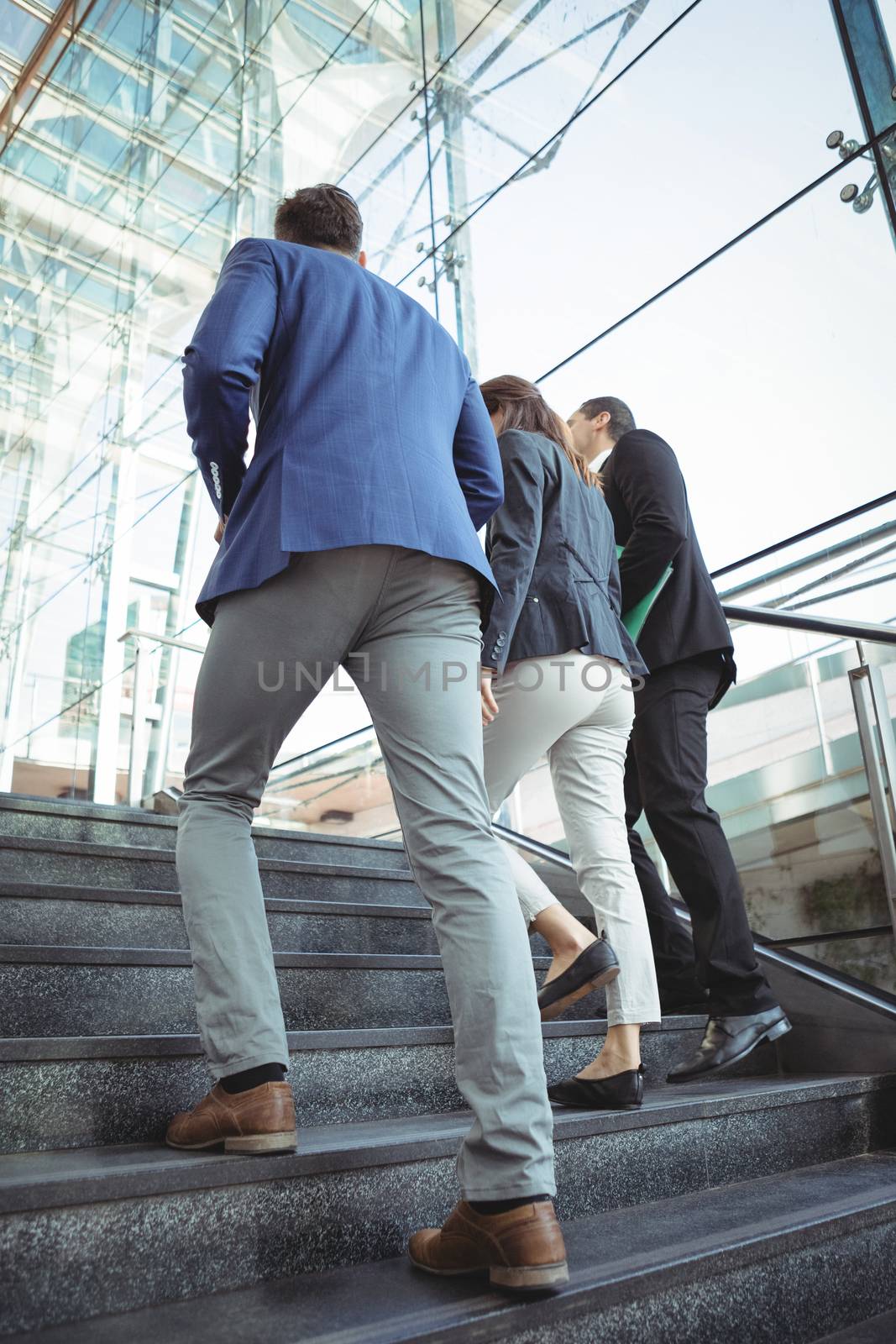 rear view of business executives walking on stairs outside platform