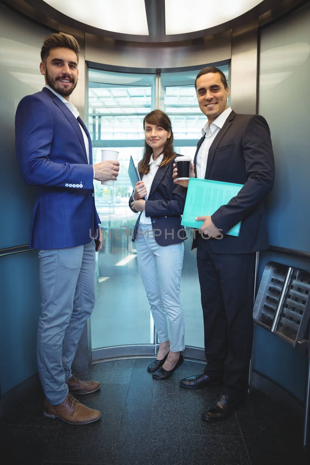 Portrait of smiling business executives standing in lift