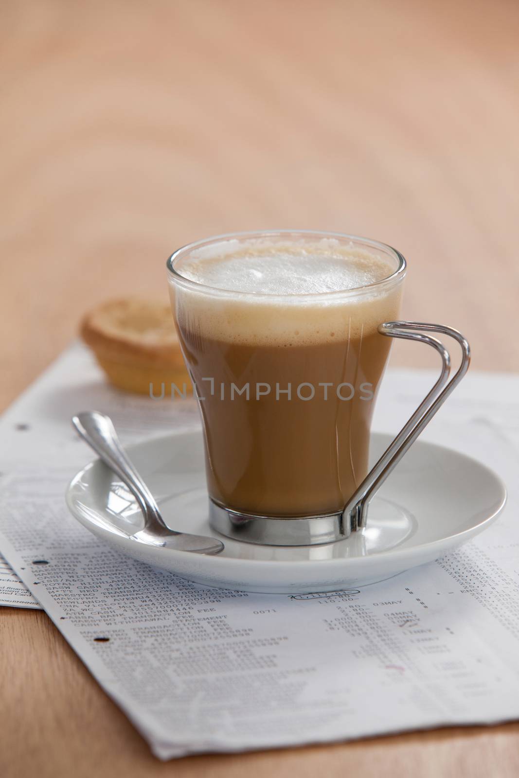 Coffee cup with saucer, spoon and documents on wooden background