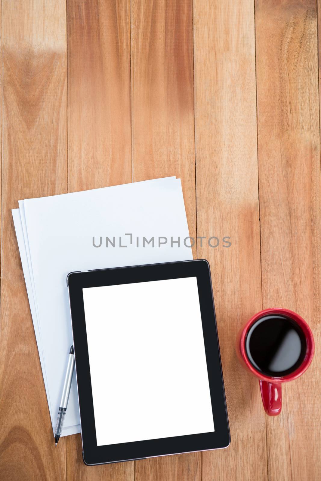 Coffee with digital tablet and paper on wooden table
