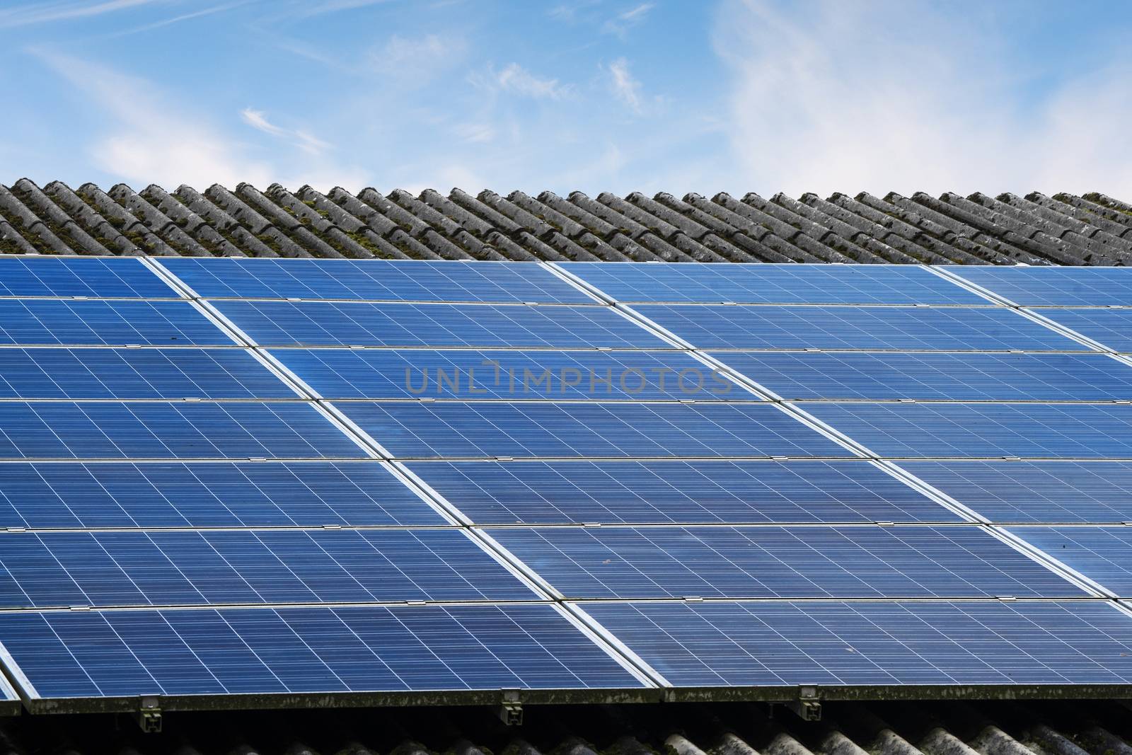 Sun panels on a roof in bright daylight under a blue sky