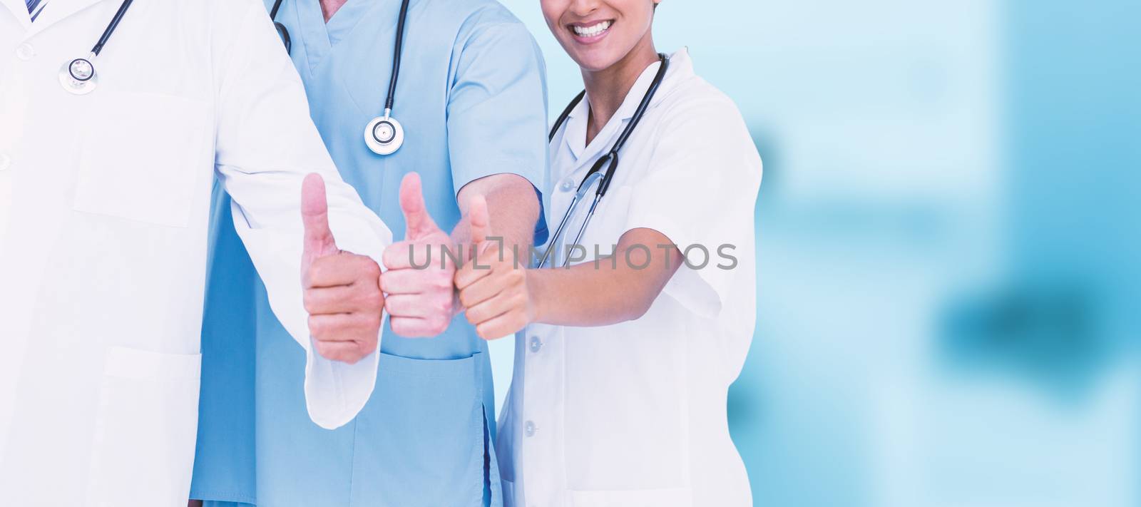 Portrait of smiling doctors with thumbs up against dental equipment