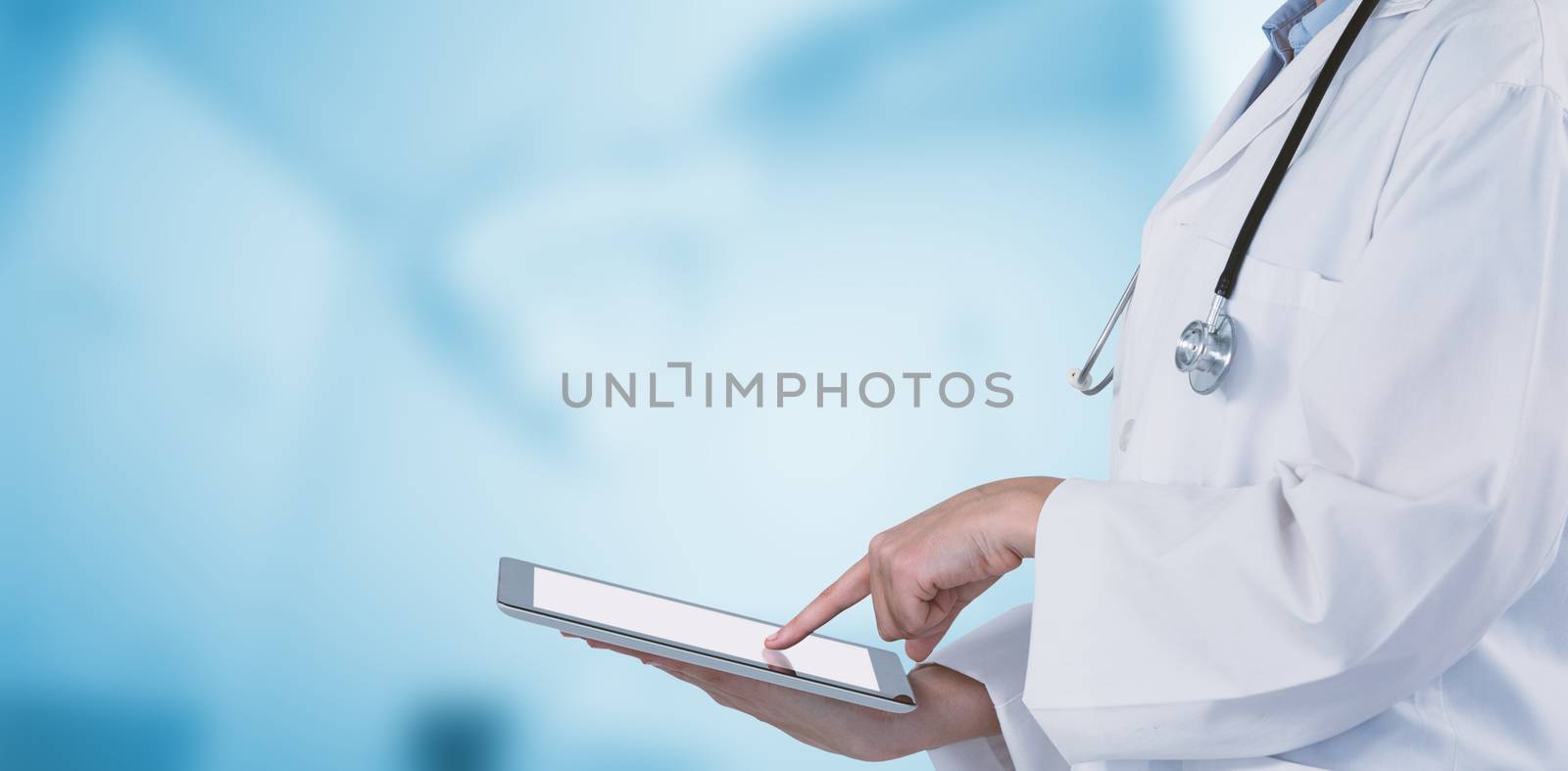 Midsection of female doctor using digital tablet against dental equipment