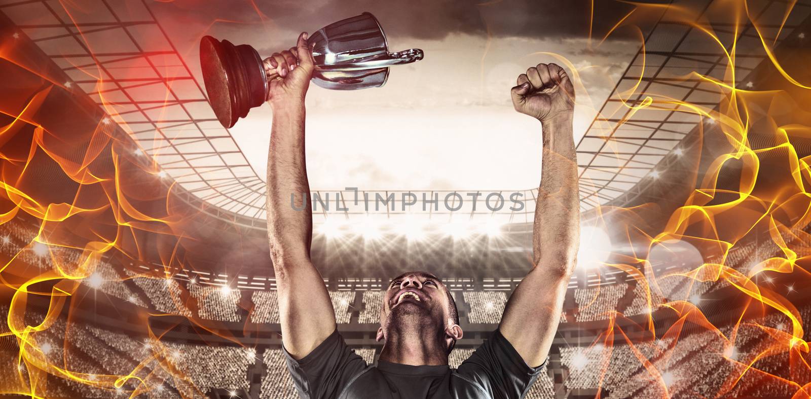 Abstract orange glowing black background against happy rugby player holding trophy