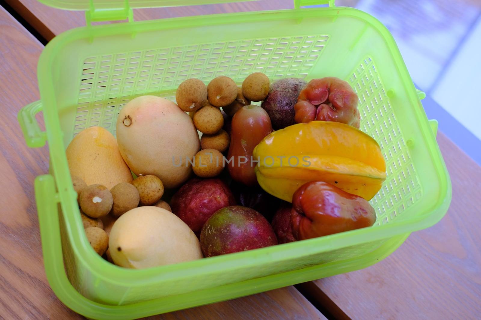 Green Plastic container box full with fresh ripe tropical fruits for transportarion. Tourism concept. Top view.