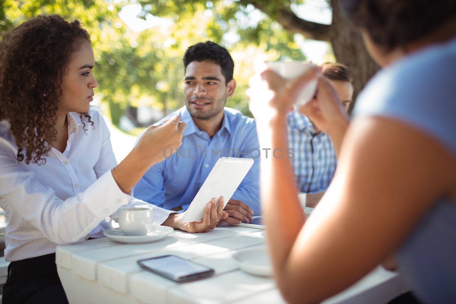 Group of friends interacting with each other in outdoors restaurant