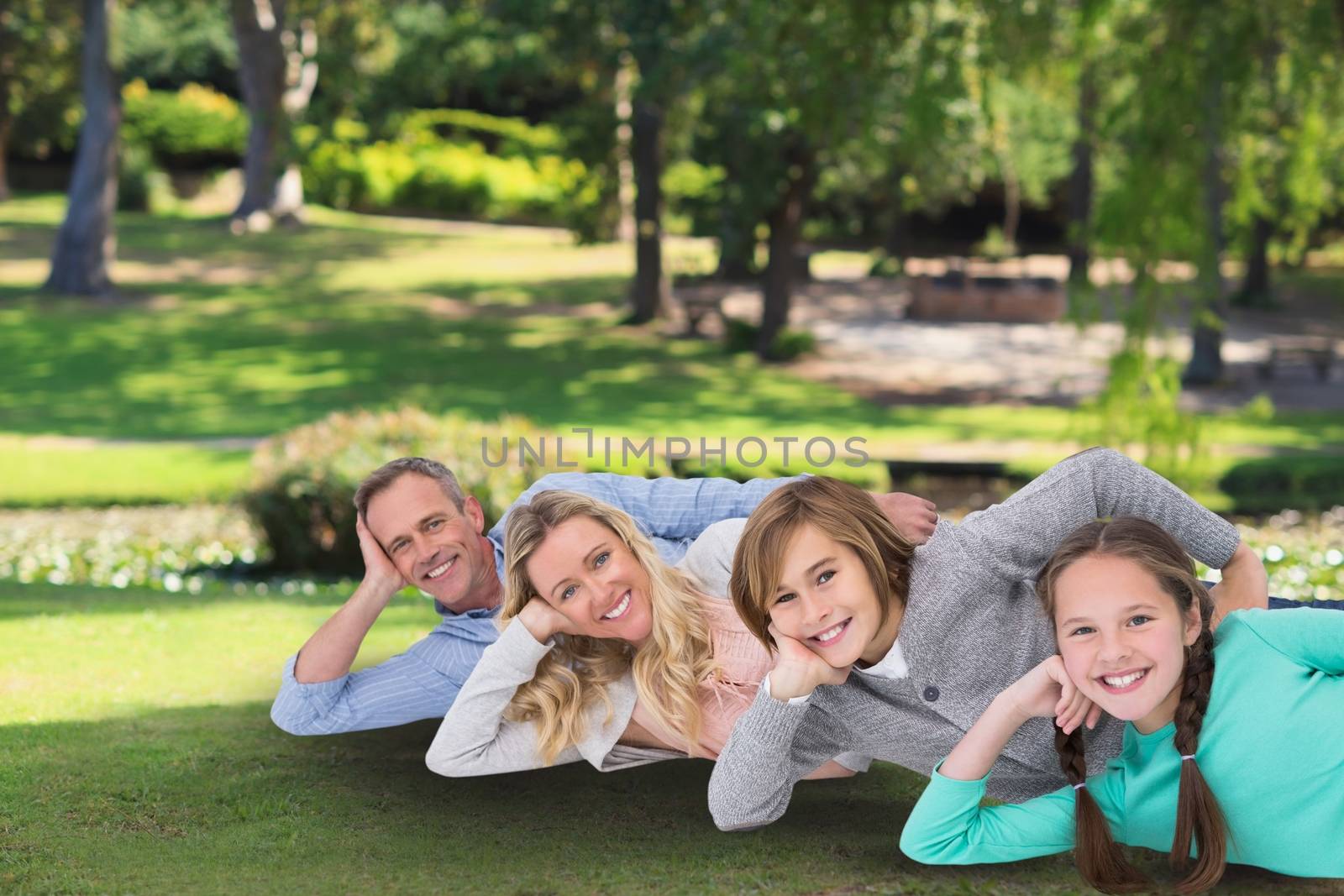 family laying on the grass by Wavebreakmedia