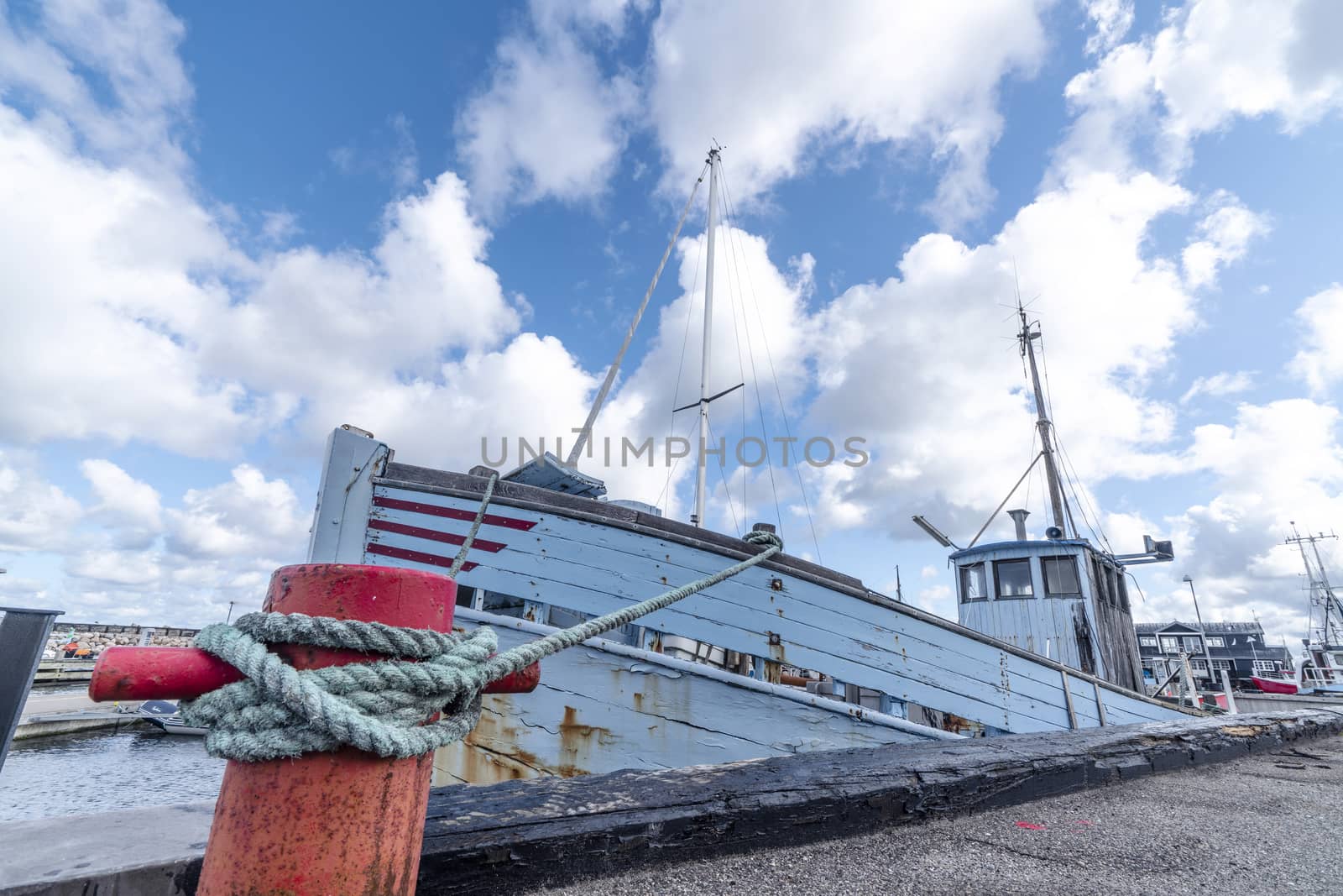 Fishing boat in a Scandinavian harbor in retro blue colors under a blue sky