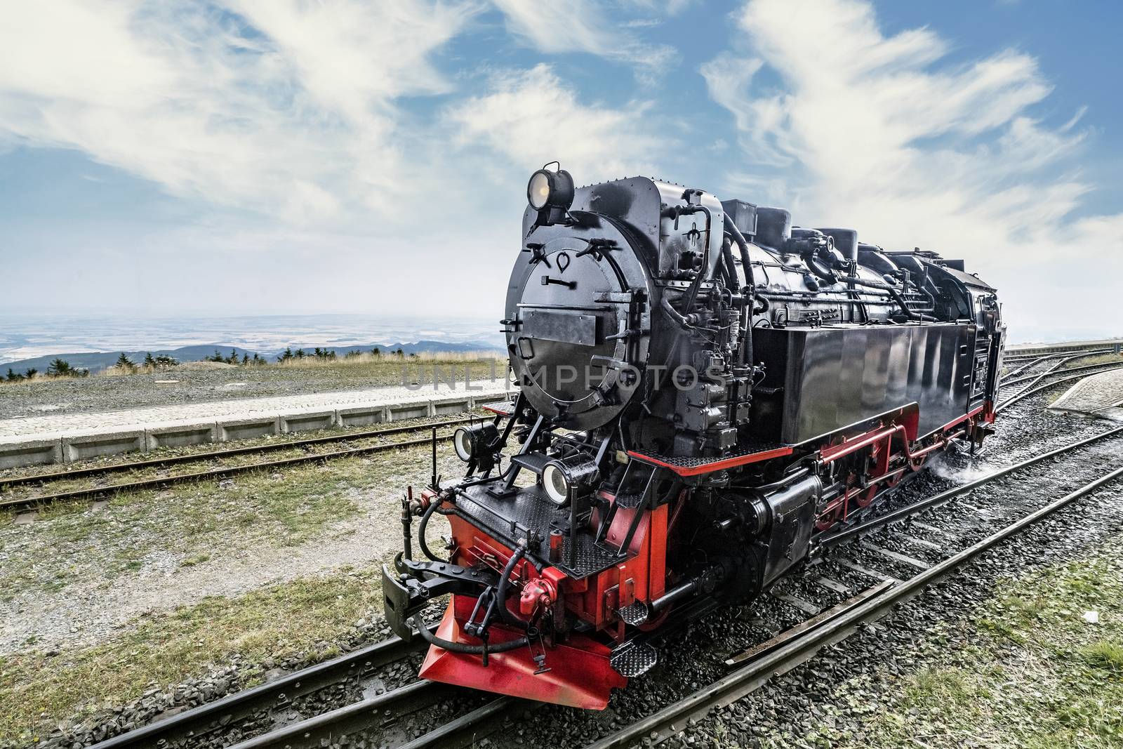 Locomotive on railroad tracks at a station by Sportactive