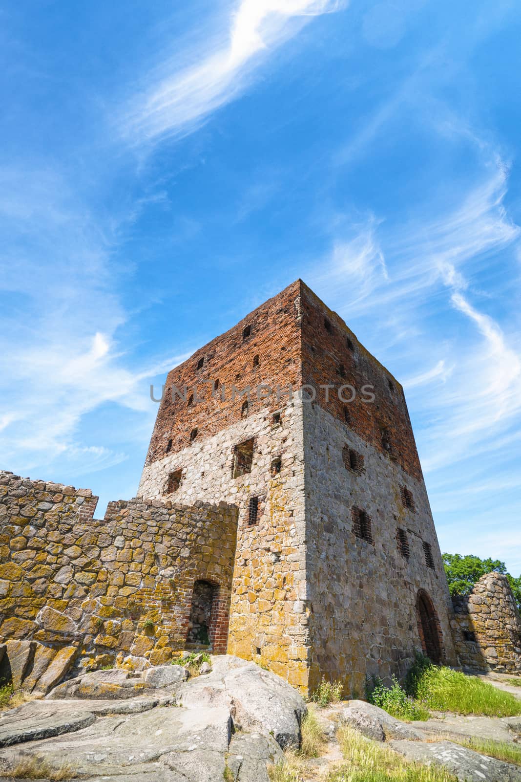 Old castle ruin in the summer under a blue sky with several windows and a brick wall