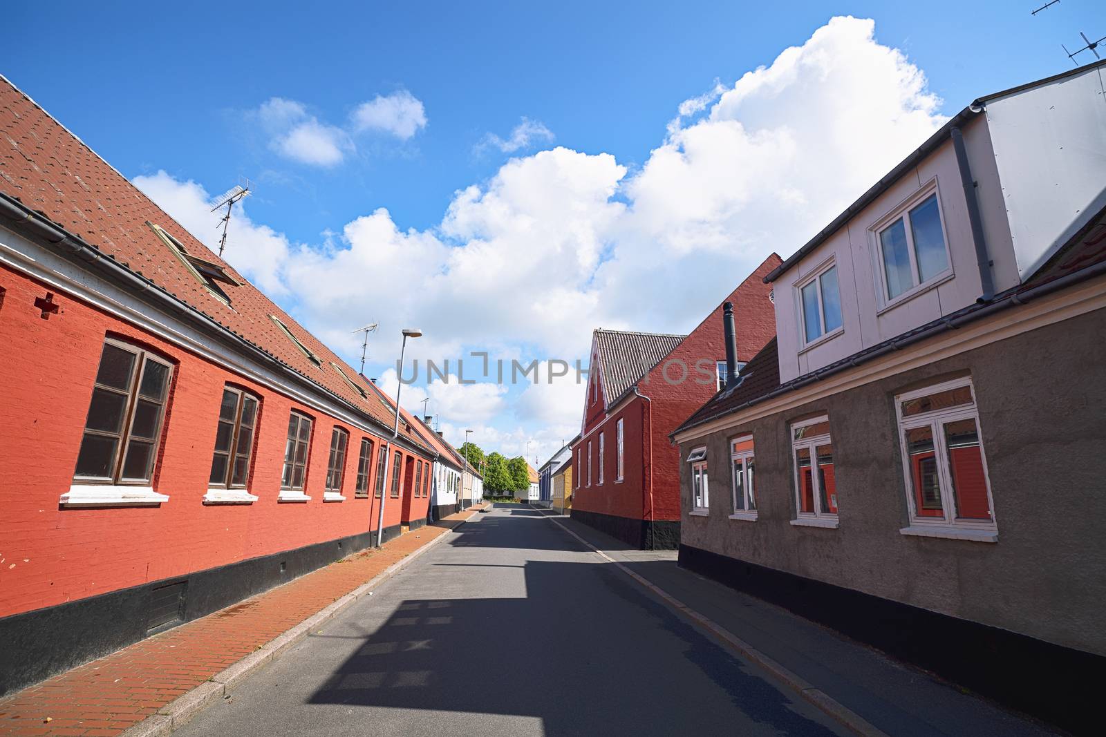 Empty street with red buildings under a blue sky in the summer