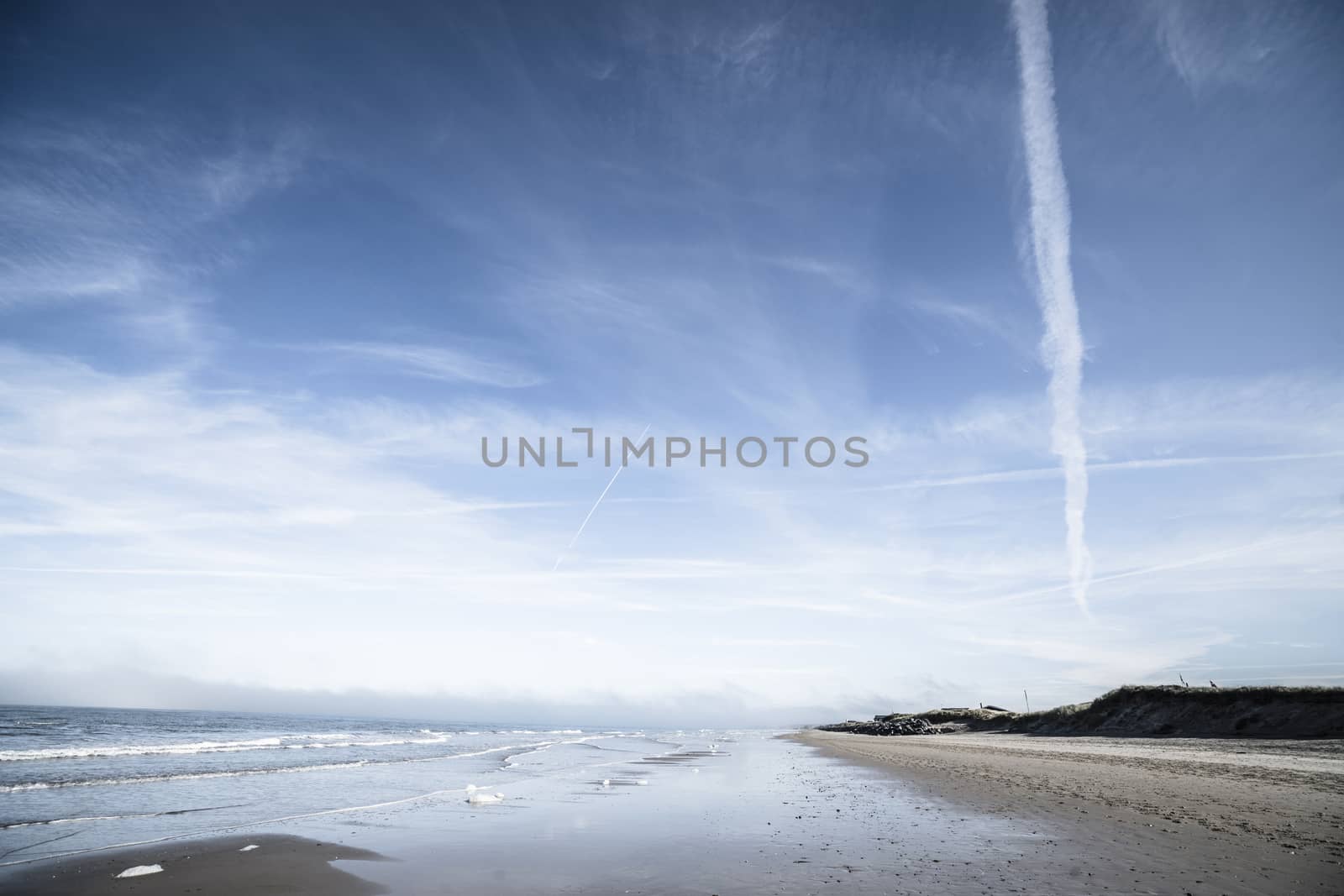 Northern beach with waves coing in under a dramatic blue sky