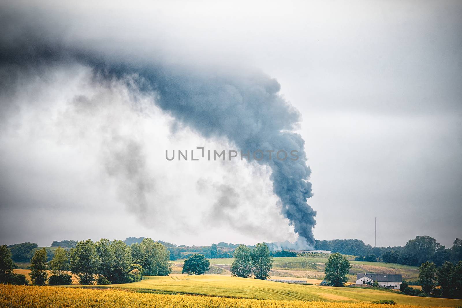 Black smoke from a fire in a rural countryside by Sportactive