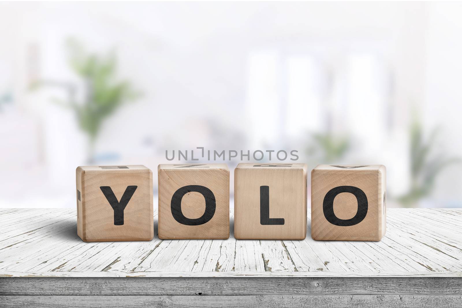 Yolo abbreviation sign in a bright living room on a white table