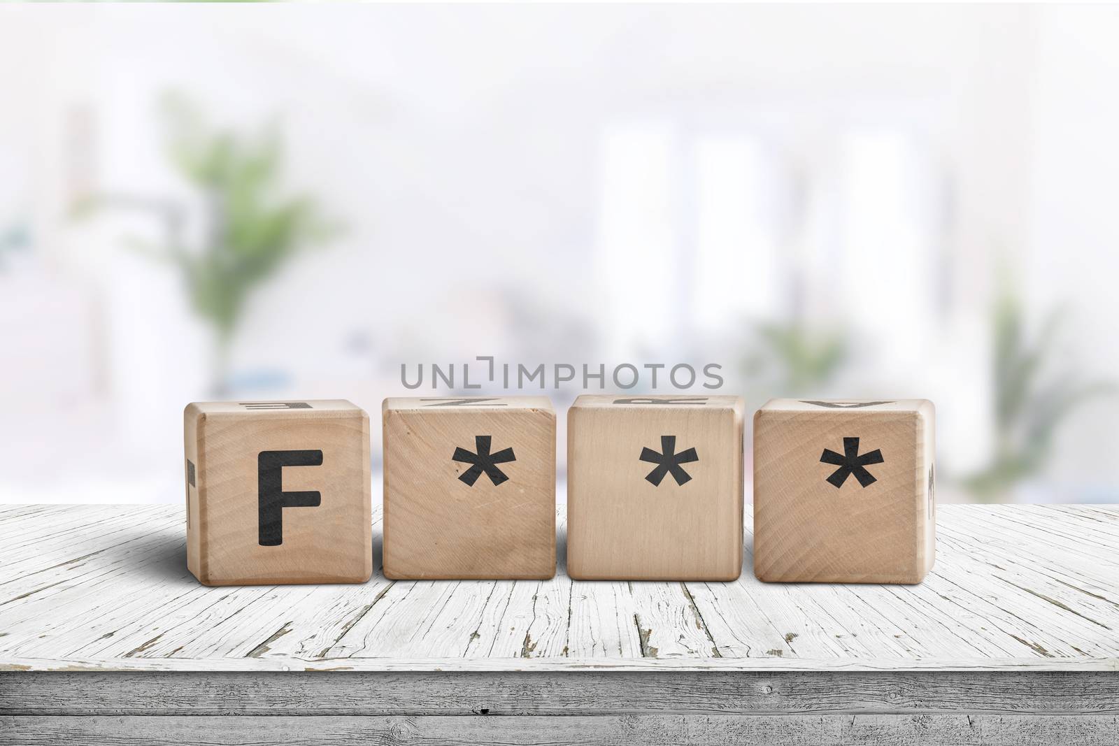 The F word censored on a wooden sign in a bright room on a plank desk