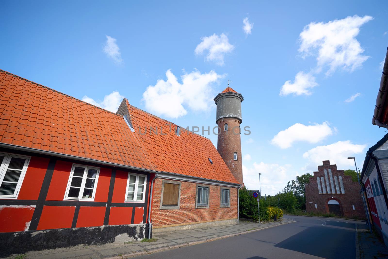 City street with a tower in a small village in Denmark under a blue sky