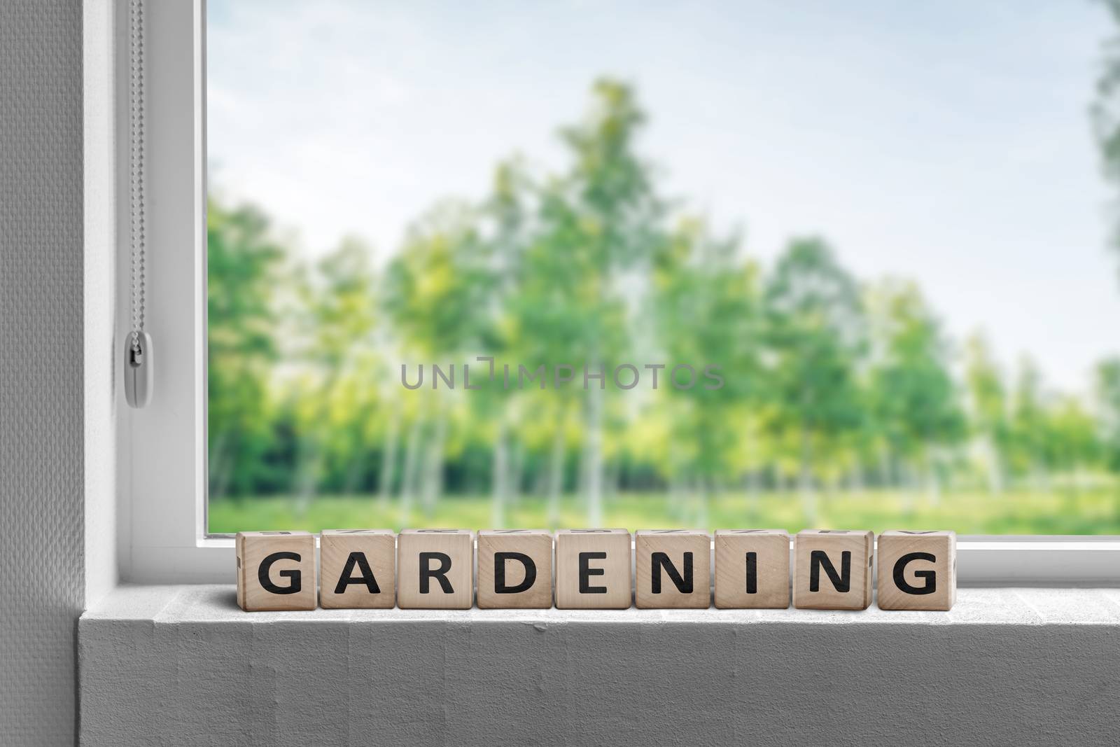 View to a garden in the spring with a gardening sign in a window sill