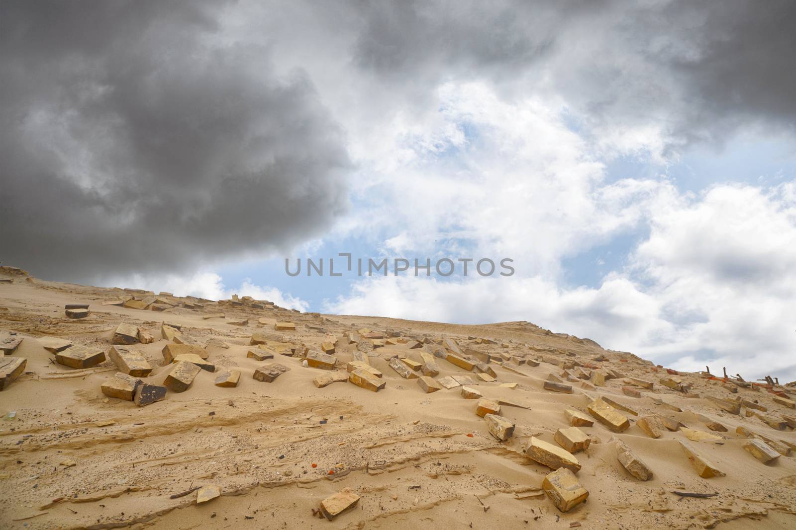 Bricks in the sand left remains of a building in the desert under a blue sky