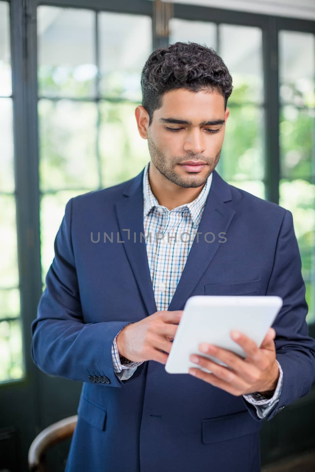 Portrait of businessman using digital tablet by Wavebreakmedia