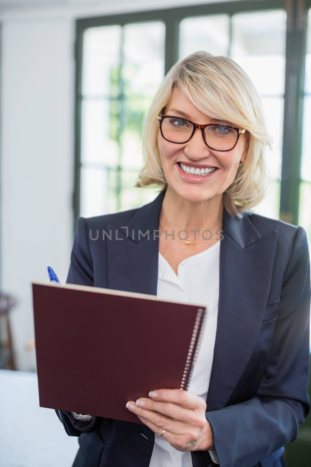 Portrait of businesswoman writing on diary in a restaurant