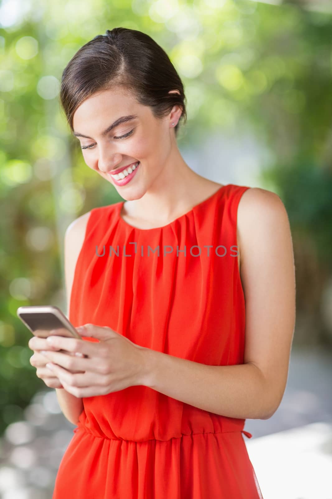 Beautiful woman smiling while using mobile phone