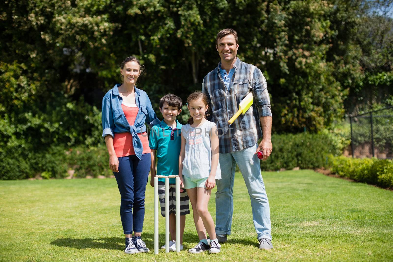 Family playing cricket in park by Wavebreakmedia