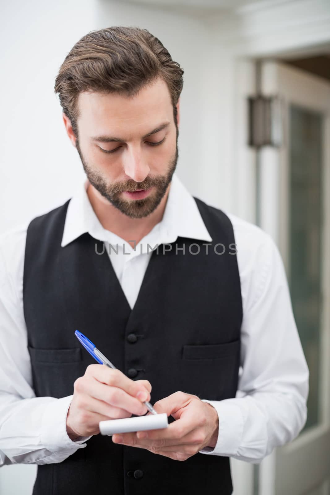 Male waiter taking down order in the restaurant