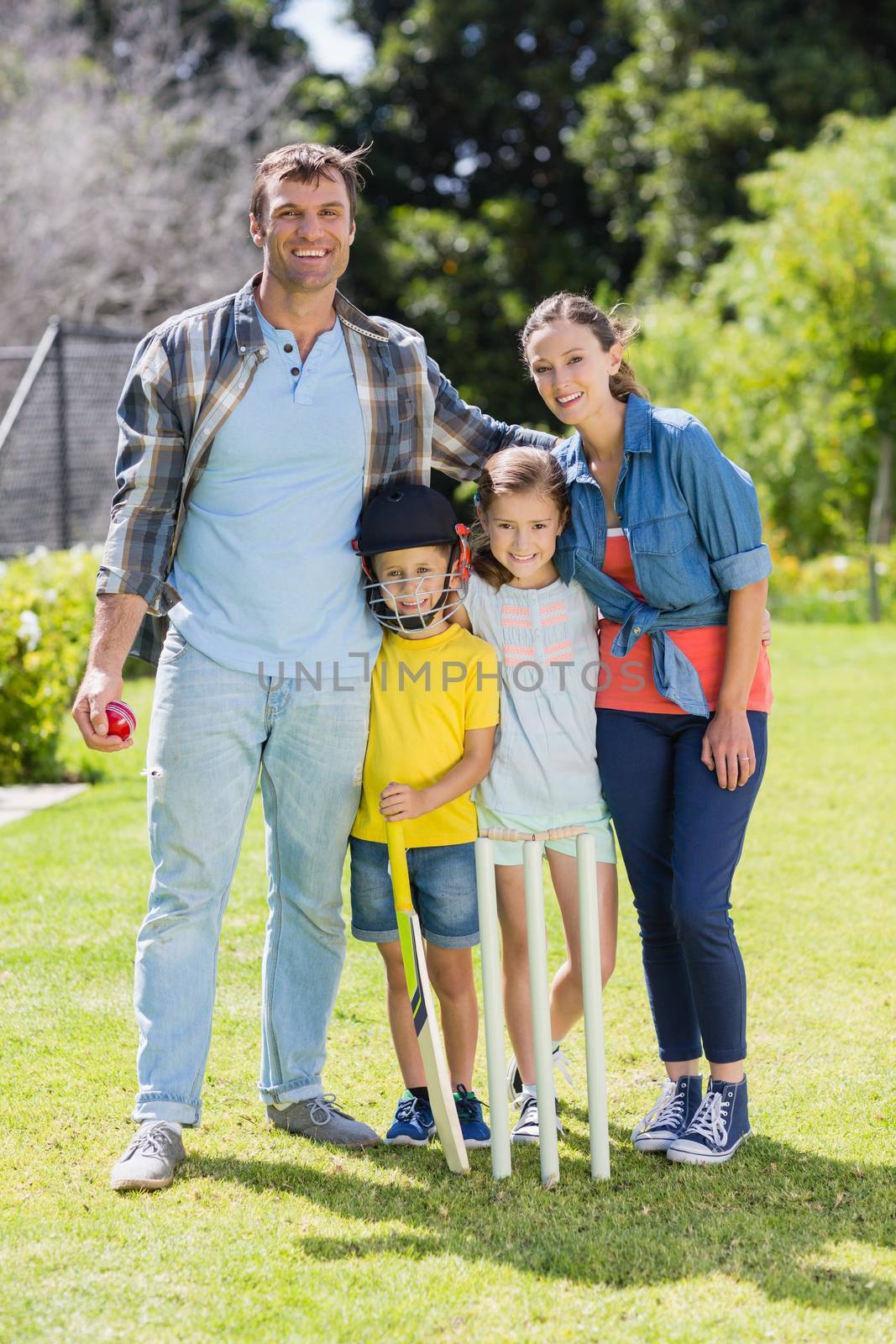 Portrait of happy family playing cricket together in backyard by Wavebreakmedia