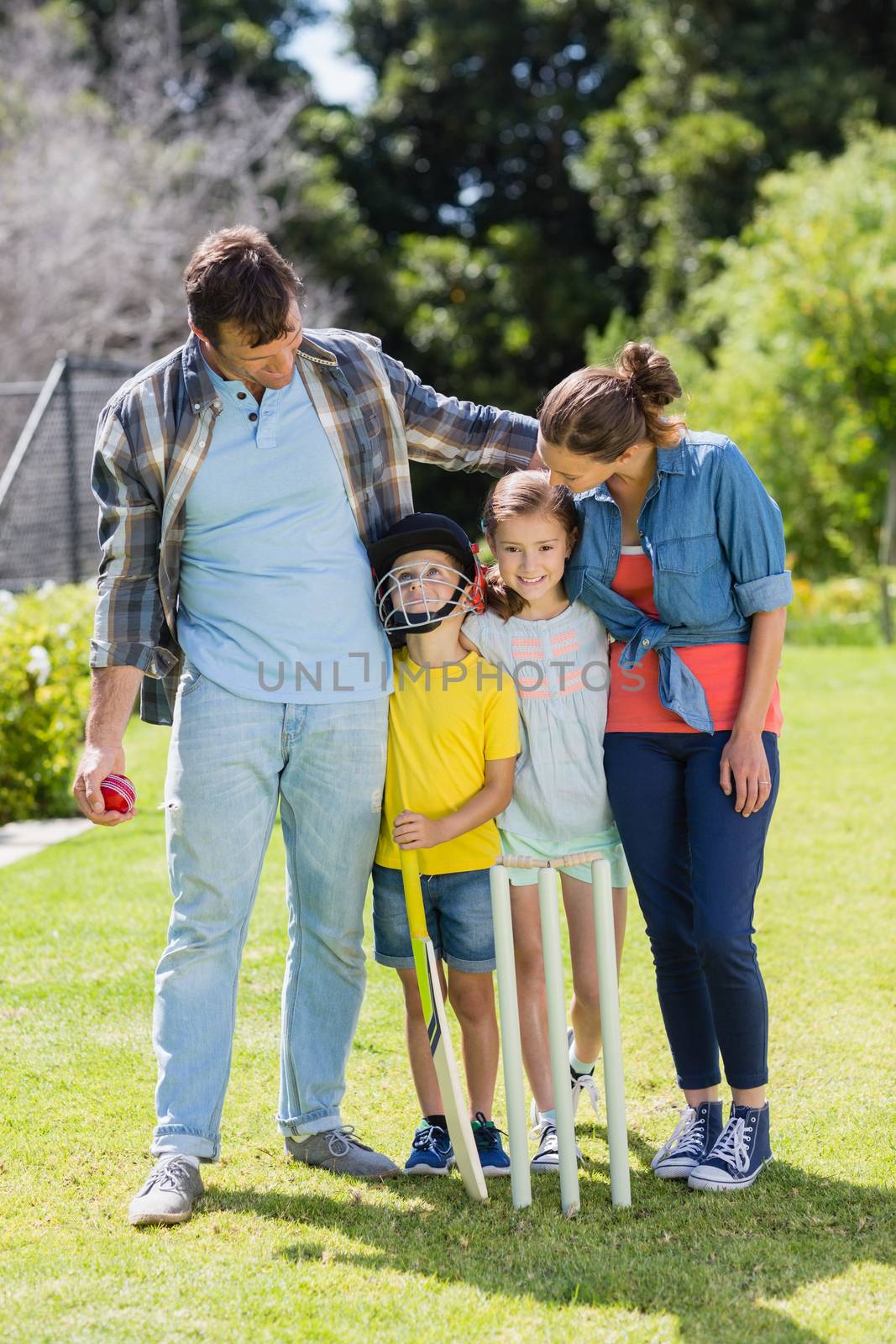 Happy family playing cricket together in backyard by Wavebreakmedia