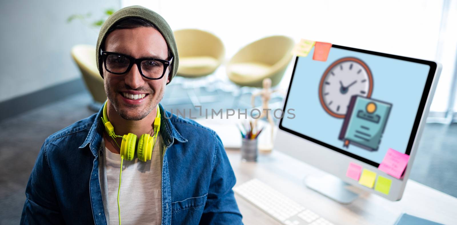Print against man smiling while sitting on chair by computer