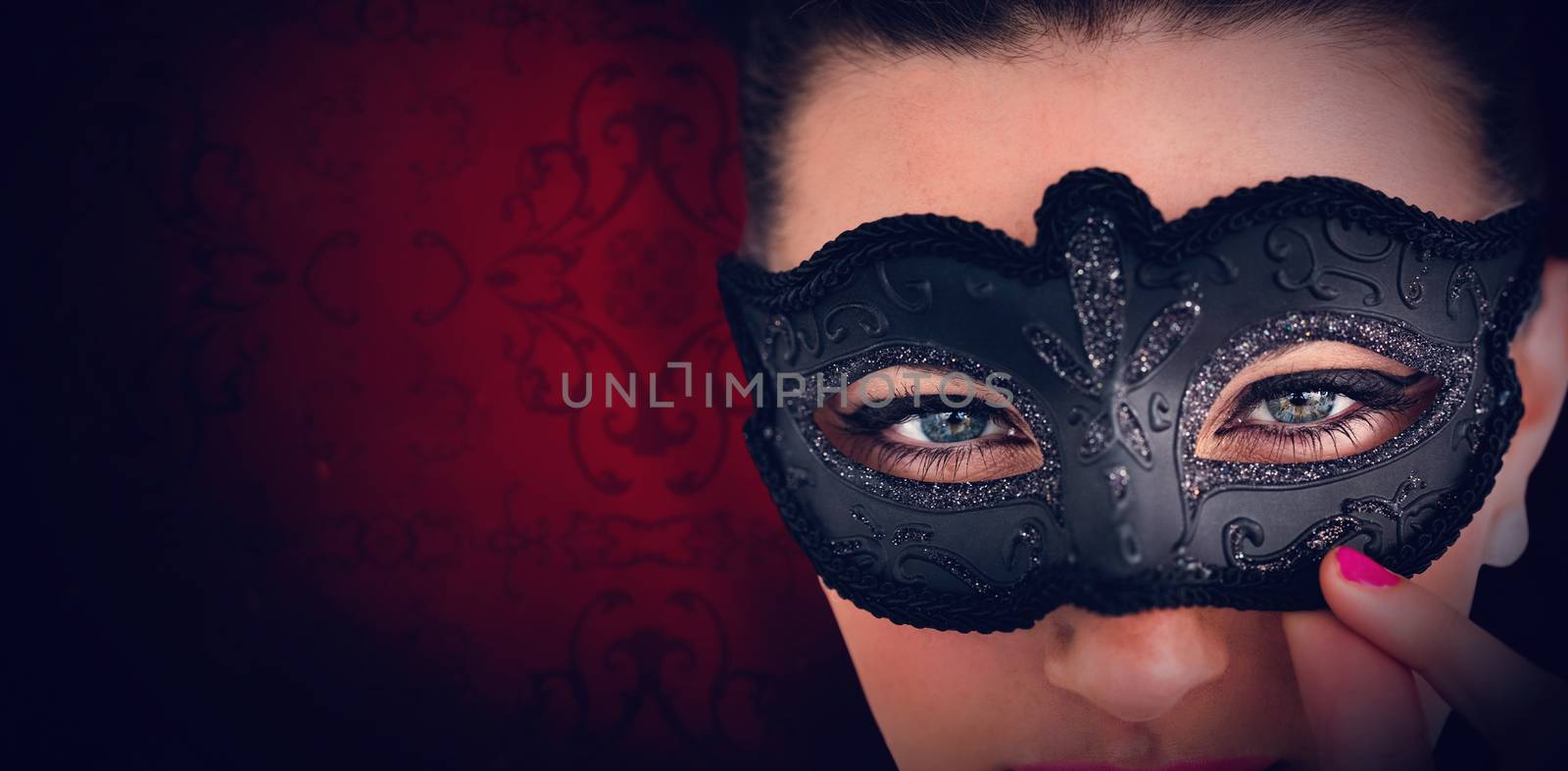 Elegant patterned wallpaper in red tones against portrait of woman wearing masquerade mask