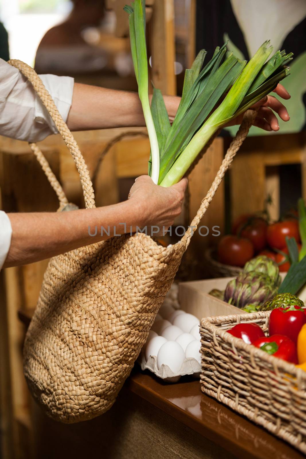 Woman buying leafy vegetable at organic section by Wavebreakmedia