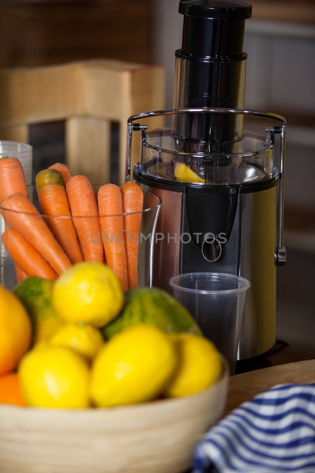 Juicer with carrot and lemon in a bowl at health grocery shop