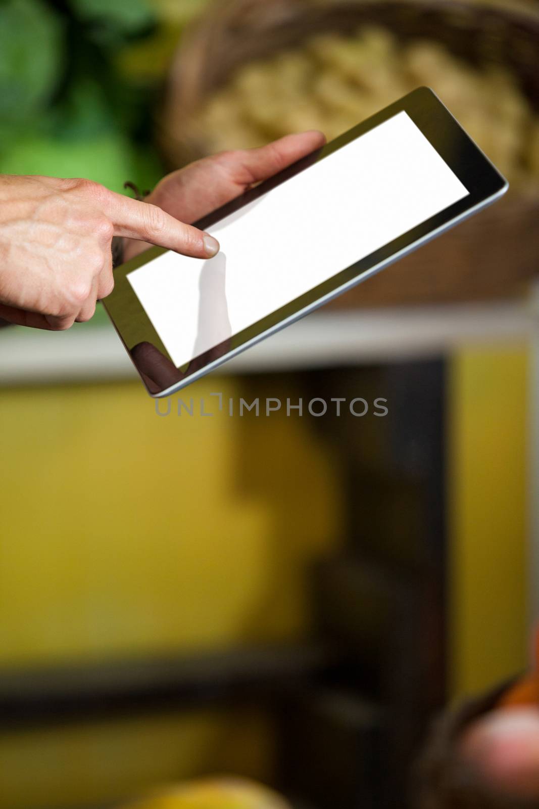 Hands of male staff using digital tablet in supermarket