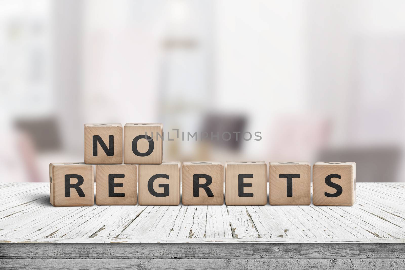 No regrets sign made with wooden blocks on a table in a bright room