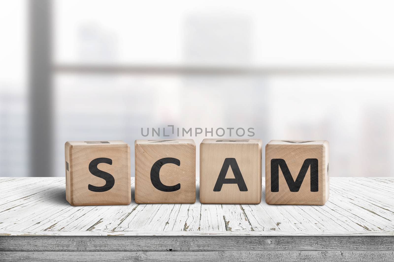 The word scam made of wooden blocks on a table in a bright office room