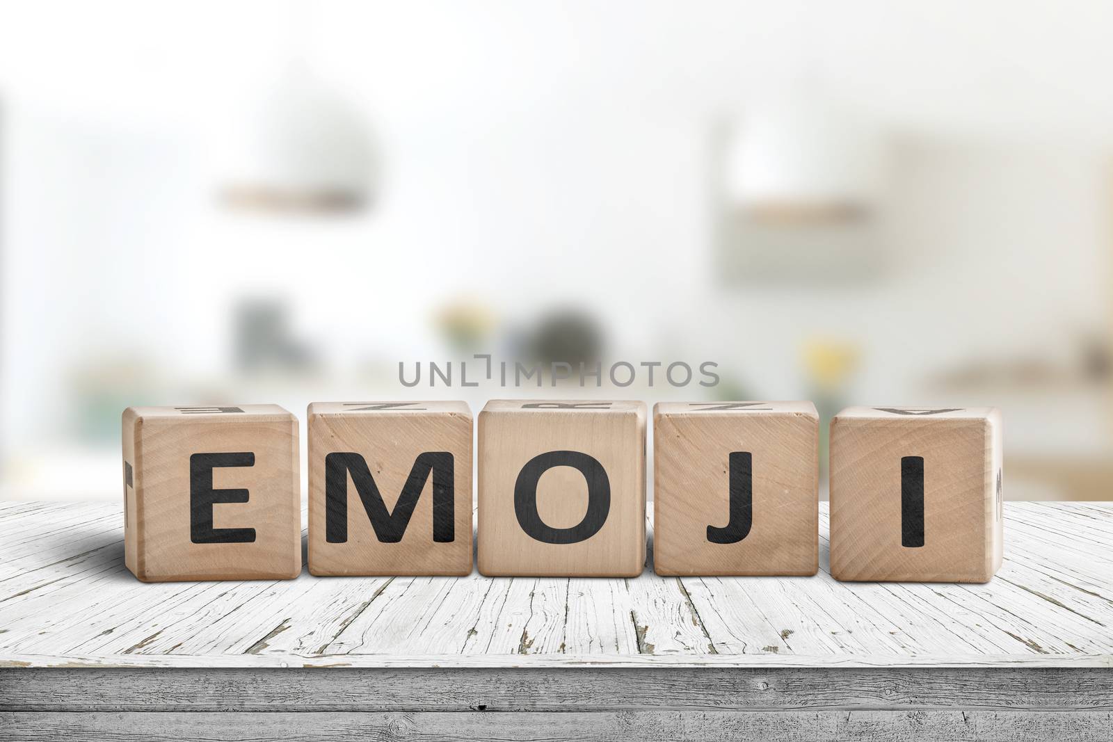 The word emoji on a wooden sign in a bright room on a white desk