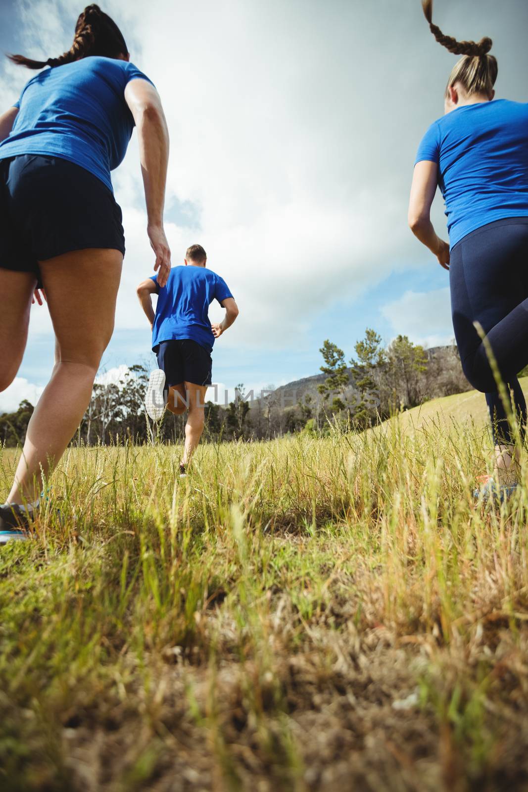 Rear view of fit people running in bootcamp