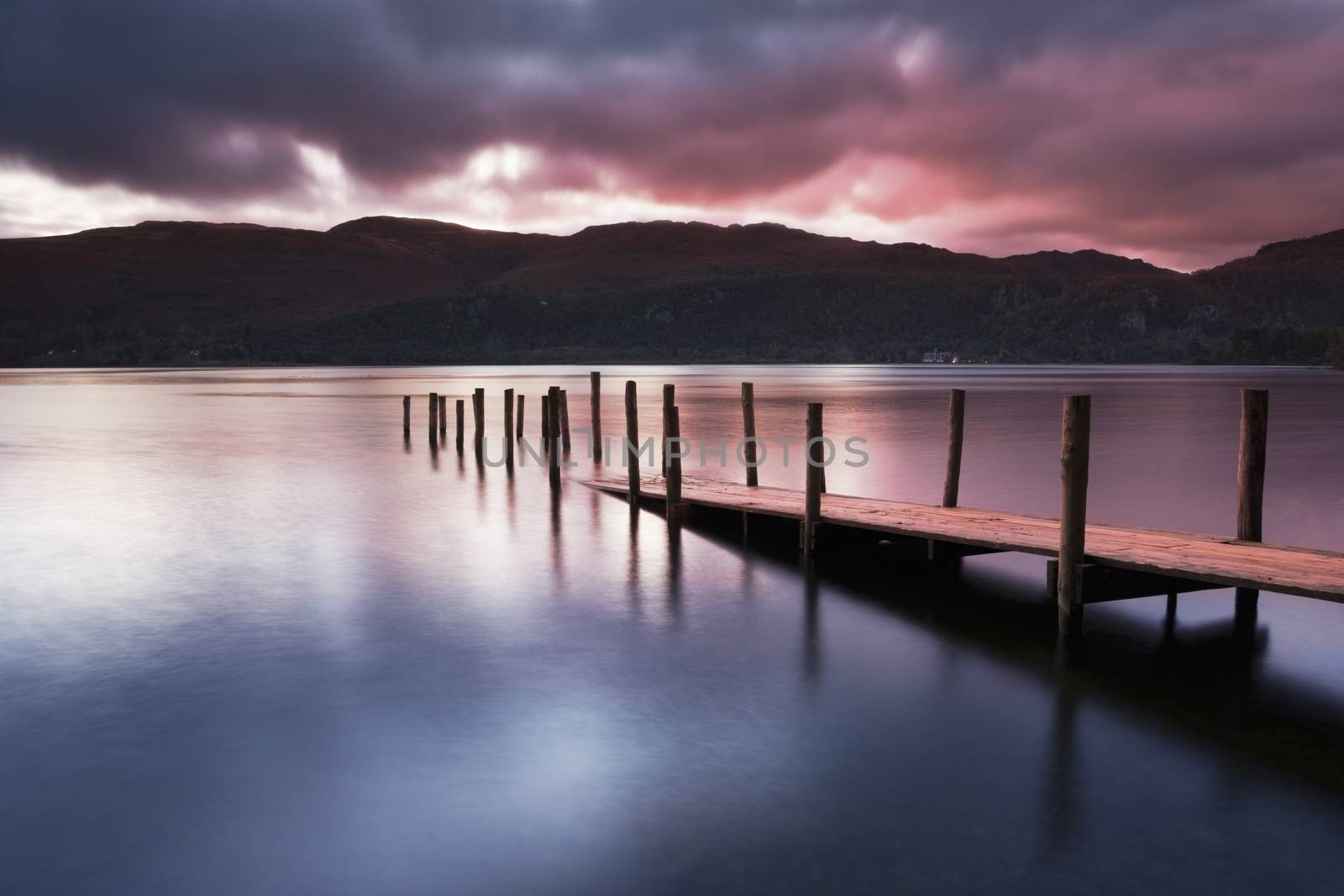 A view across Derwent water lake at dawn, with Jetty in foreground.
Lake District
Cumbria.
England




England