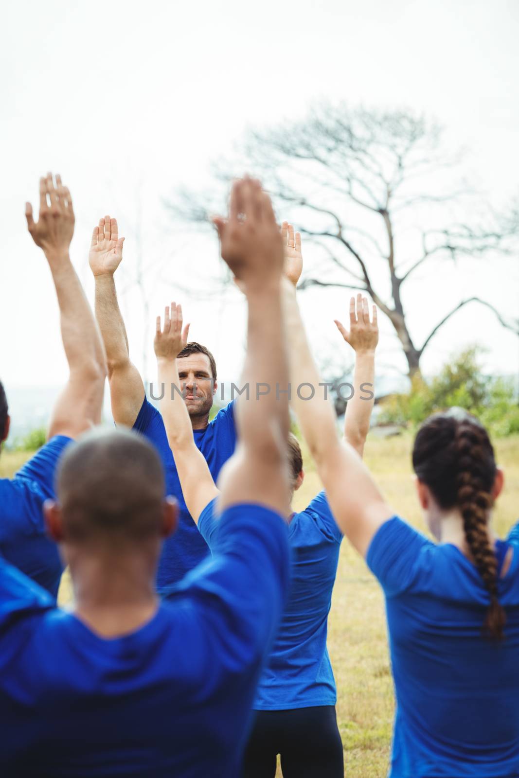 Fit people performing stretching exercise in bootcamp