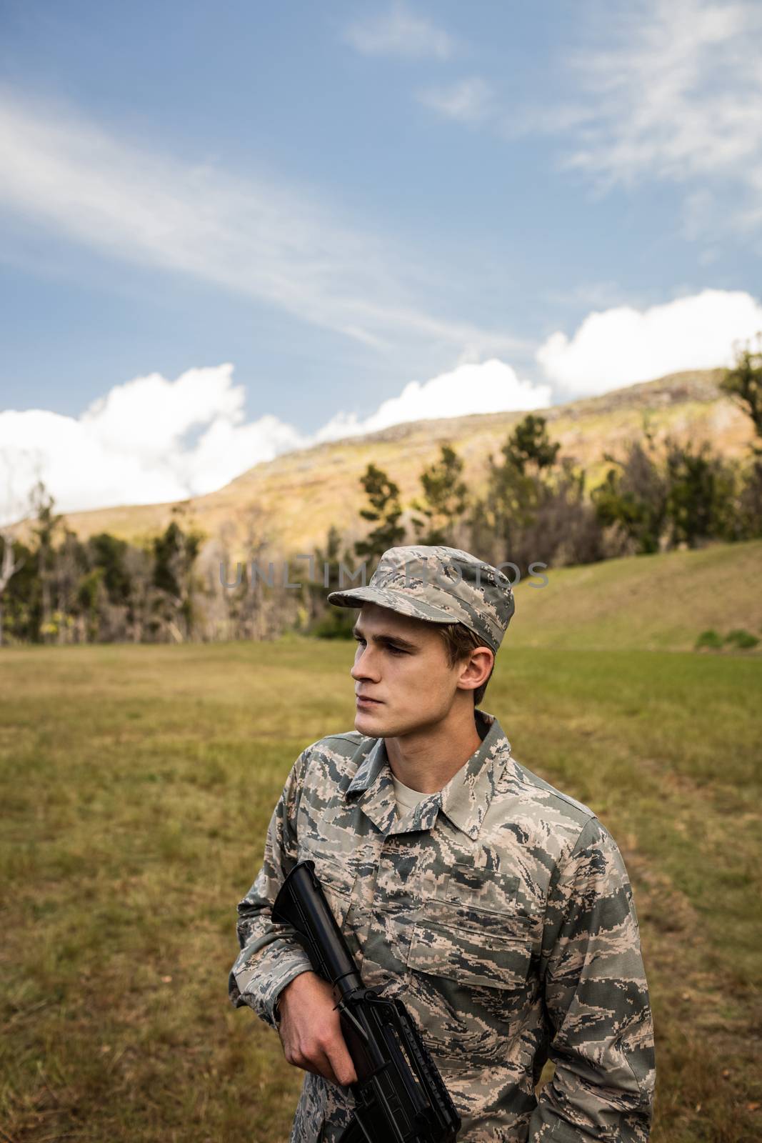 Military soldier guarding with a rifle in a boot camp