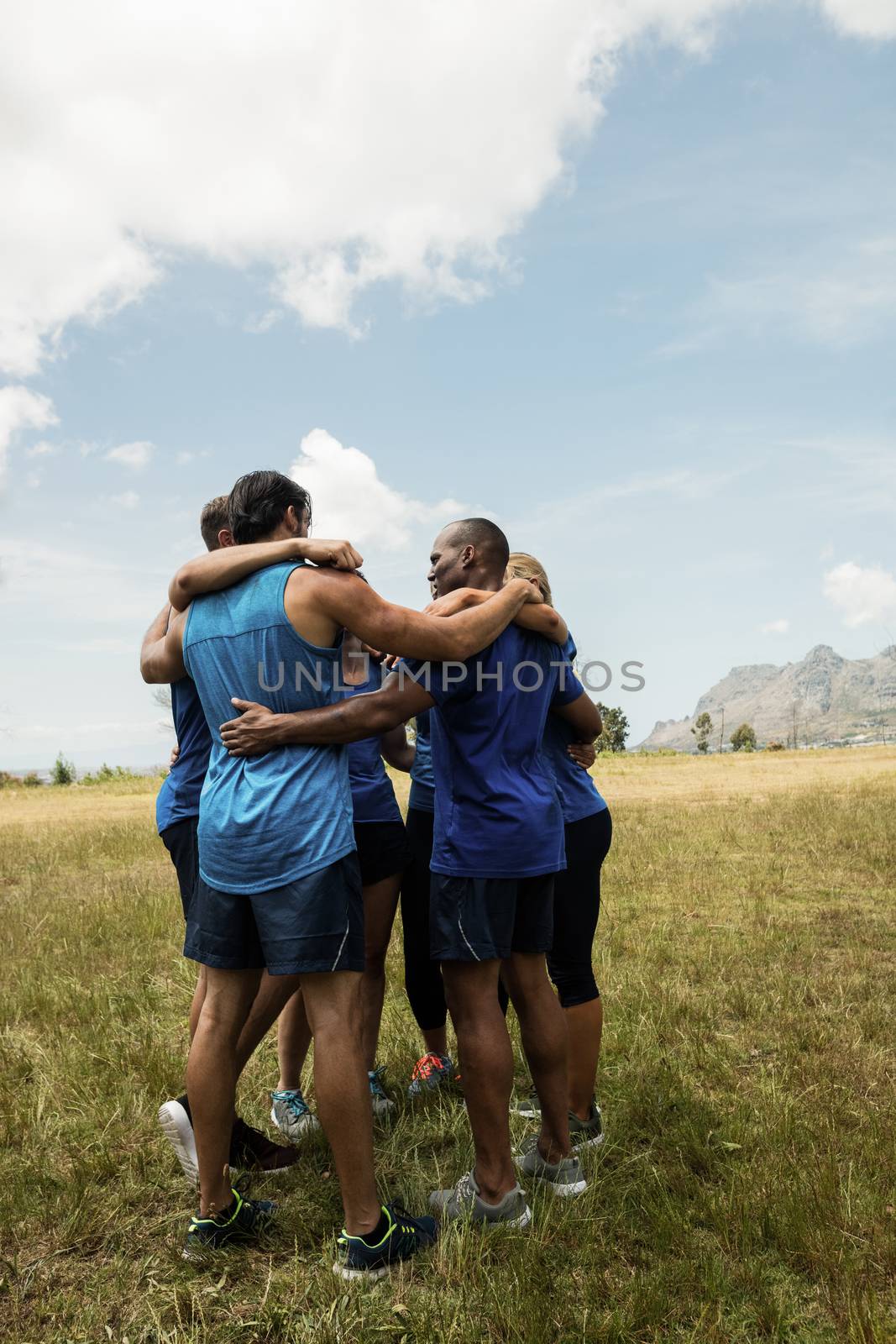 Fit people standing together and forming a hurdle in bootcamp