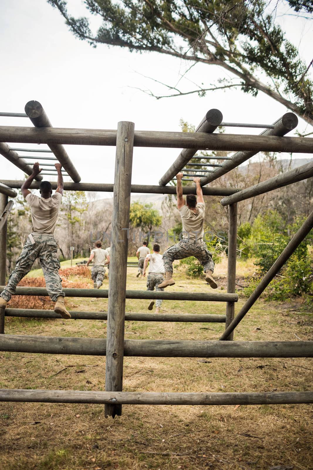 Rear view of Soldiers climbing monkey bars