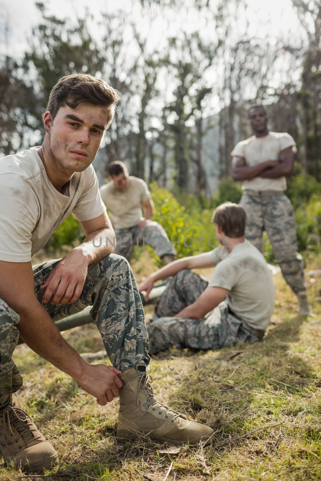 Soldier tying his shoe laces in boot camp by Wavebreakmedia