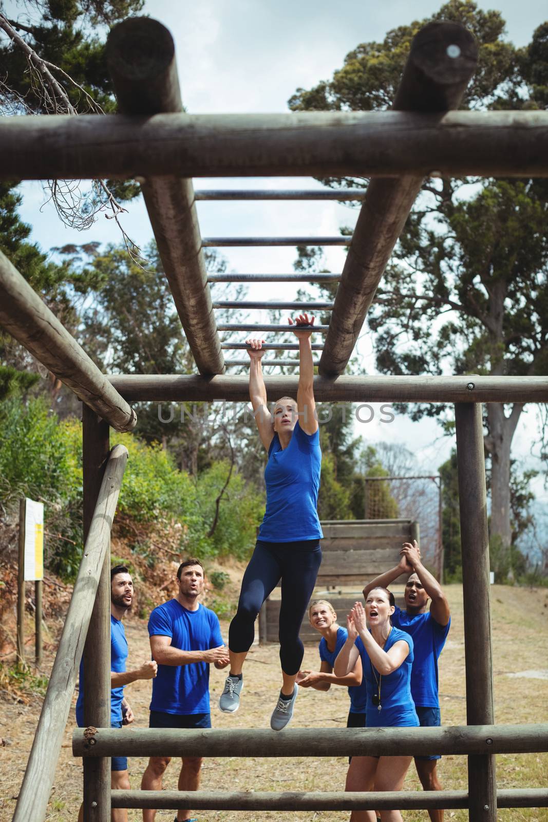 Fit woman climbing monkey bars by Wavebreakmedia