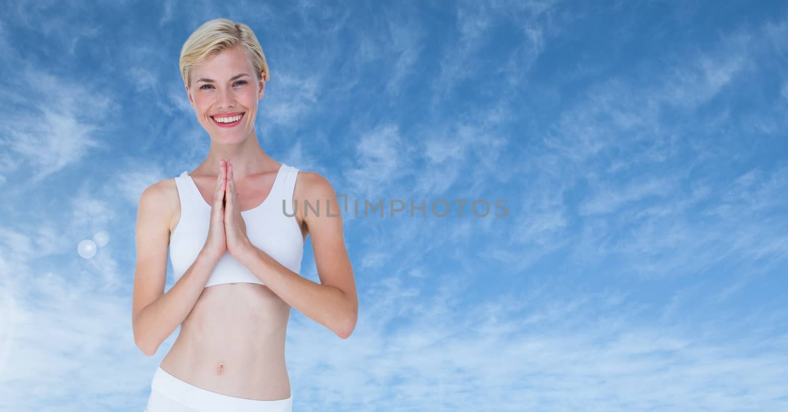 Digital composite of Woman praying yoga Meditating by blue clouds