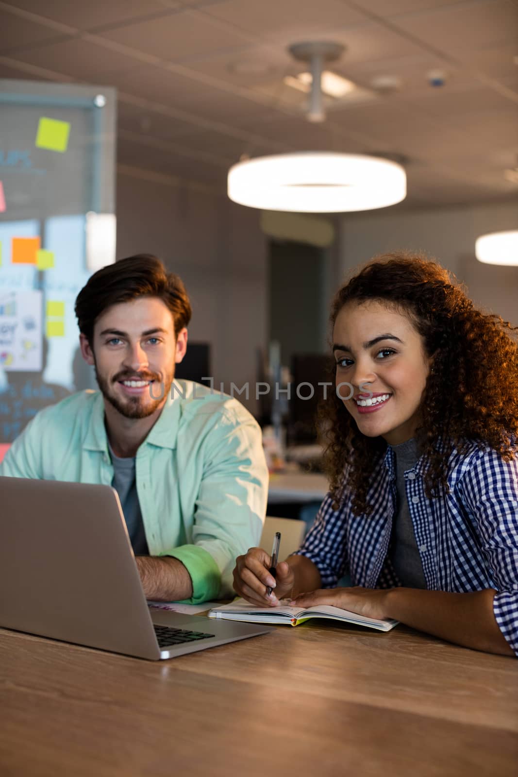 Portrait of creative business people working on desk at office