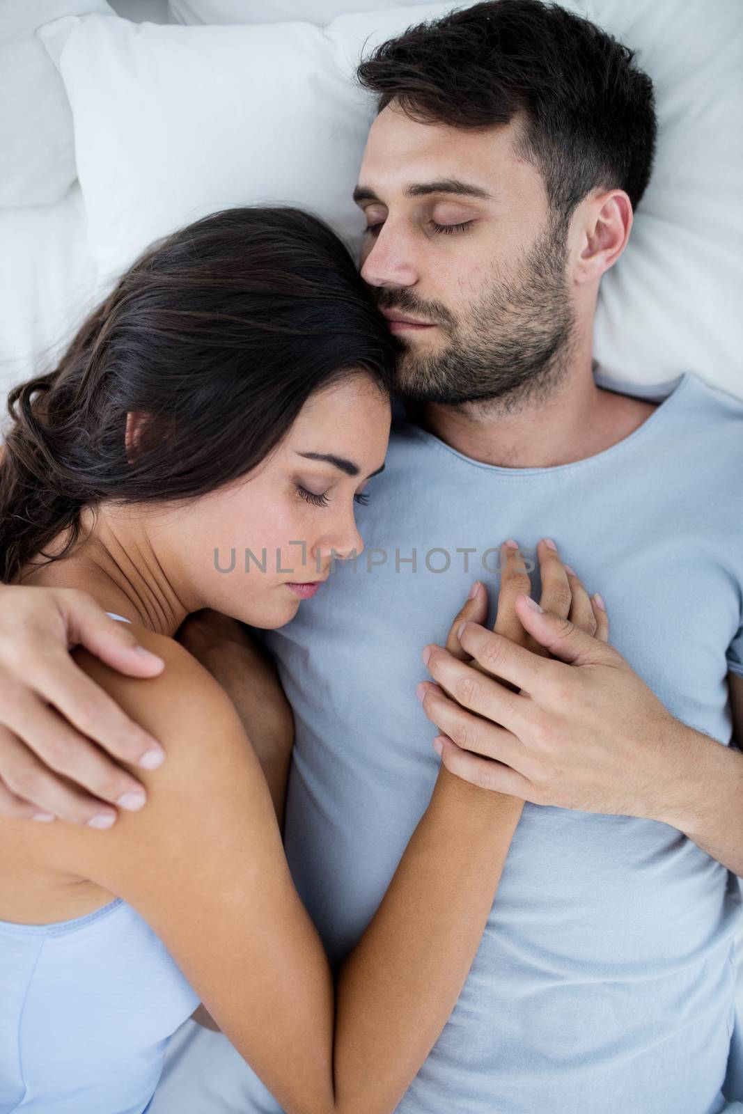 Young romantic couple sleeping on bedÂ in bedroom