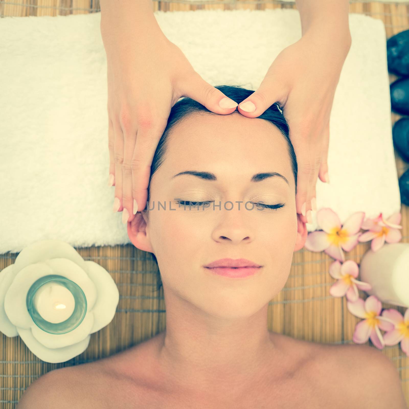 Smiling brunette enjoying a head massage in the health spa